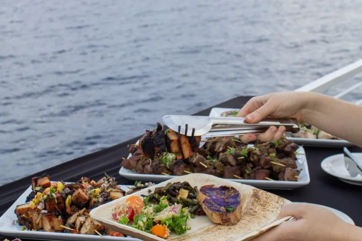 a person sitting at a table with food and water