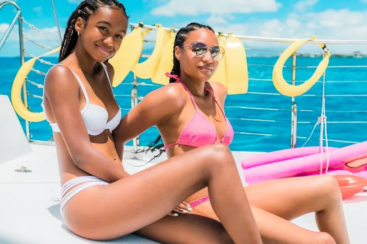 a woman sitting next to a body of water