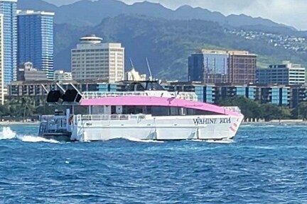 a large ship in a body of water with a city in the background