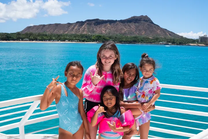 a group of people sitting on a bench next to a body of water