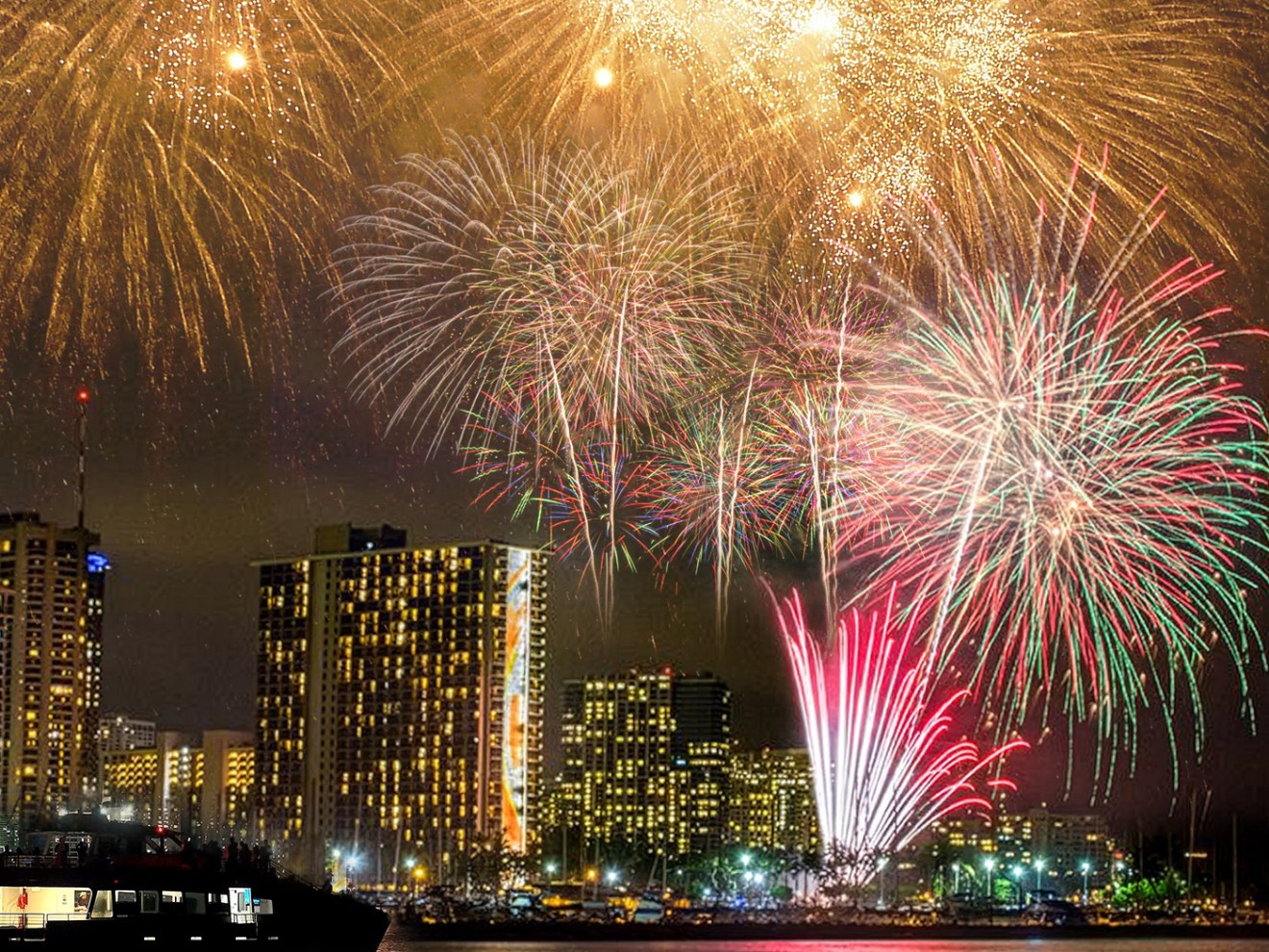 Vibrant fireworks display over city skyline at night.
