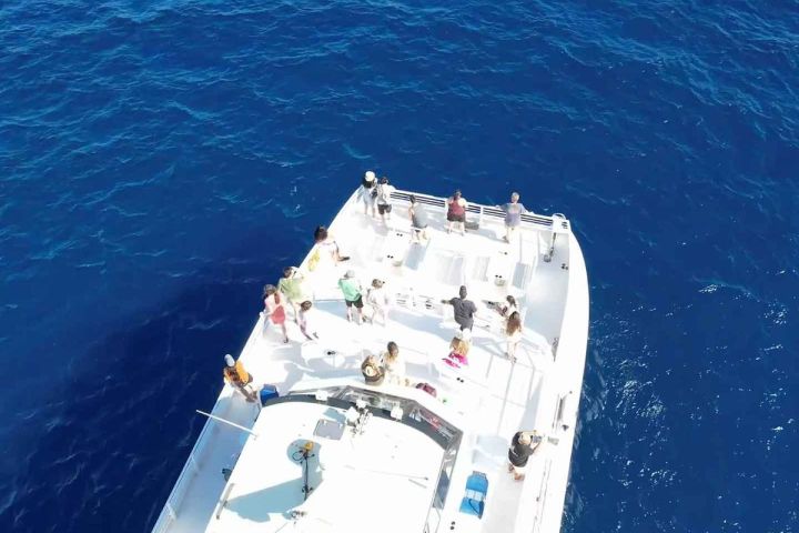 Aerial view of people on a large boat in the ocean.