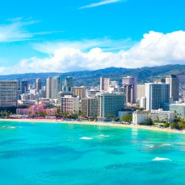 Aerial view of a city skyline with beachfront and turquoise ocean.