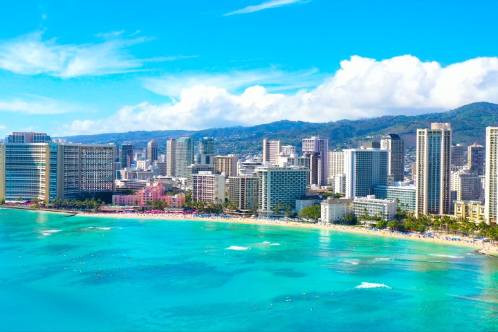 Aerial view of a city skyline with beachfront and turquoise ocean.