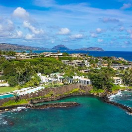 Aerial view of coastal resort with lush greenery and ocean.