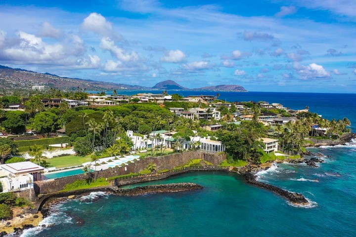 Aerial view of coastal resort with lush greenery and ocean.